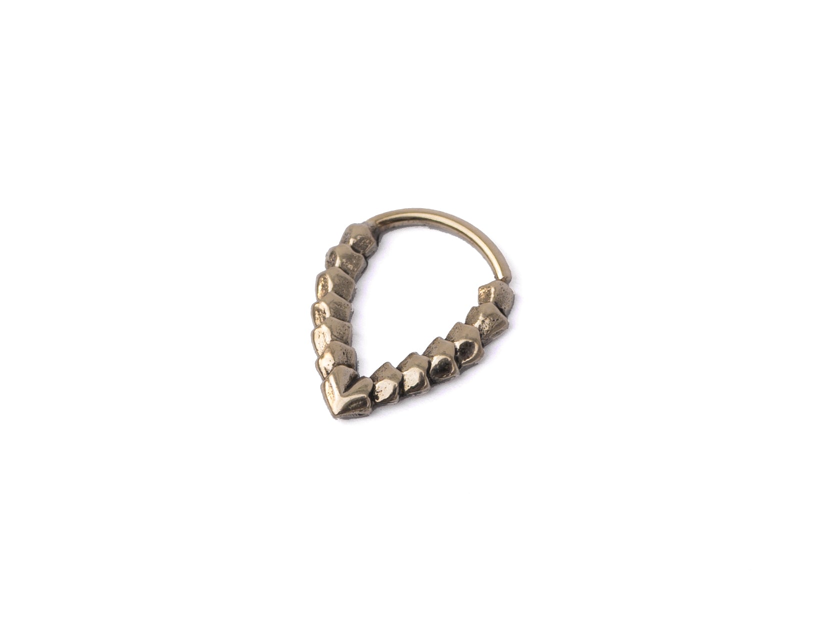 The KAMO Biomech Teardrop Septum Ring in Gold by Kaya Movement is a striking piece of jewelry, crafted from gold brass. It features a unique geometric design with connected hexagonal shapes forming a V-shape, making it stand out beautifully against a plain white background.